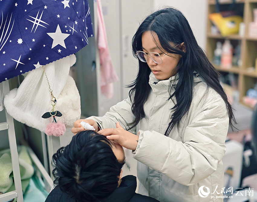 【1】陆佳慧(右)帮助小燕点眼药水。人民网 尹馨摄
