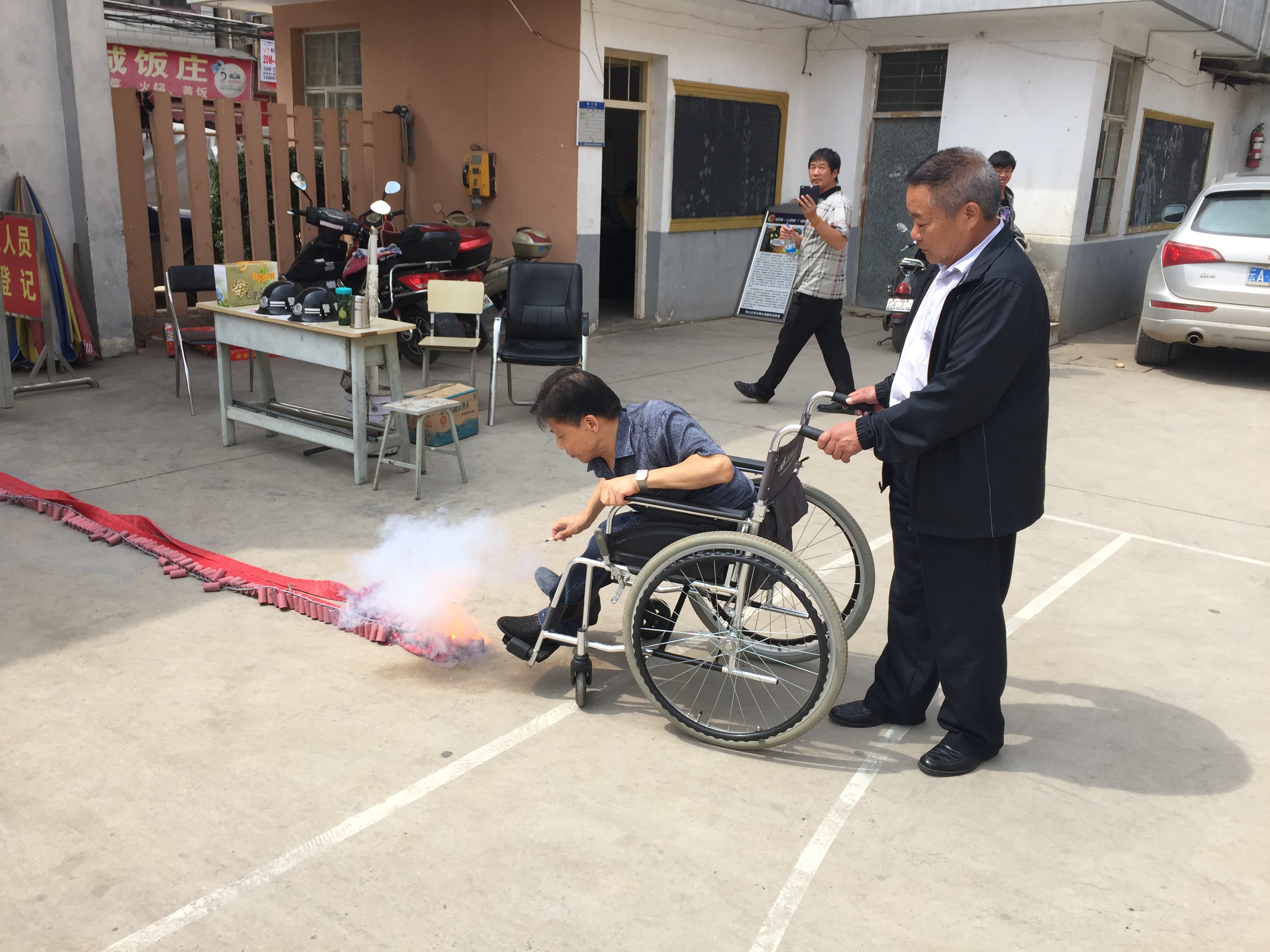 图为李鷖家长点燃喜庆的鞭炮